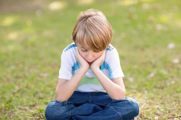 Little boy feeling sad in park — Stockfoto