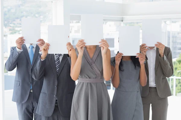 Colegas de negócios escondendo seu rosto com papel — Fotografia de Stock