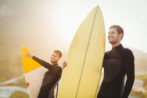 Mannen in wetsuits met surfboard op strand — Stockfoto