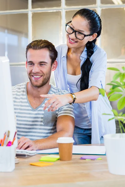 Partenaires souriants travaillant ensemble sur ordinateur — Photo