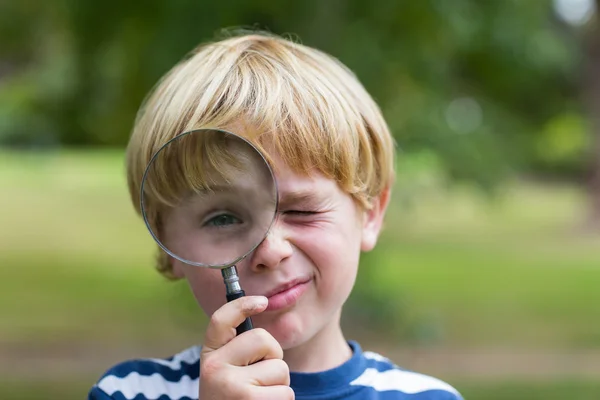 Ragazzo guardando attraverso lente d'ingrandimento — Foto Stock