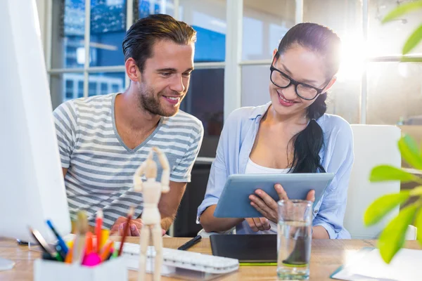 Smiling partners working together on tablet — Stok fotoğraf