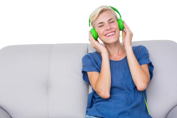 Femme écouter de la musique sur canapé — Photo