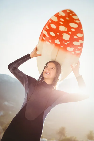 Mulher de fato de mergulho com prancha de surf na praia — Fotografia de Stock