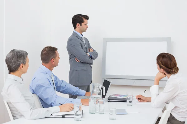 Equipo de negocios mirando la pantalla blanca — Foto de Stock