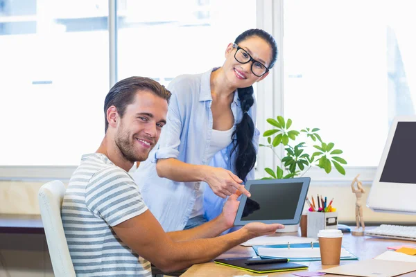 Smiling partners working together on tablet — Stockfoto