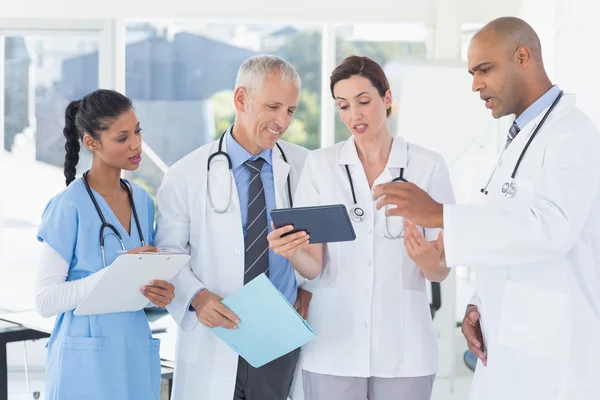 Team of doctors working together on patients file — Stock Photo, Image