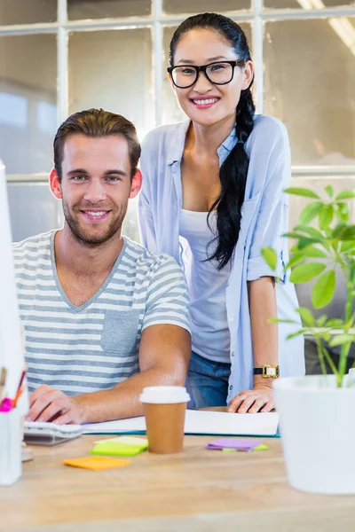 Lächelnde Partner, die gemeinsam am Computer arbeiten — Stockfoto