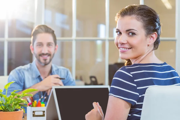 Smiling colleagues working together on laptop — Stock Photo, Image