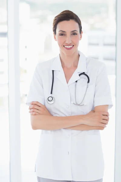 Médecin souriant regardant caméra avec les bras croisés — Photo