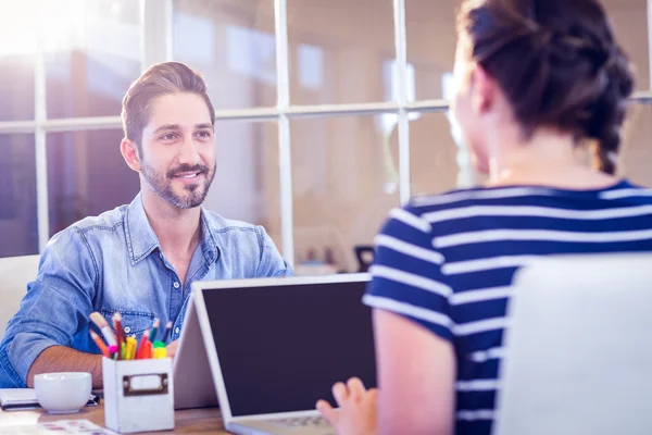 Happy creative workers sharing desk — Stock Photo, Image