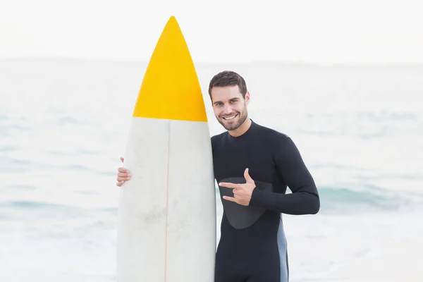 Mann im Neoprenanzug mit Surfbrett am Strand — Stockfoto