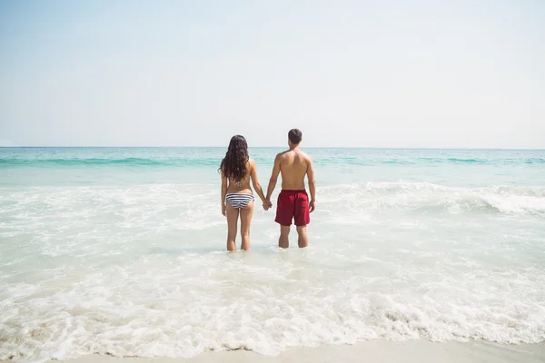 Paar hält Händchen am Strand — Stockfoto