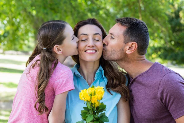 Happy family kissing at camera in the park — Stock Photo, Image