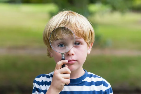 Boy looking through magnifying glass — Stock Photo, Image