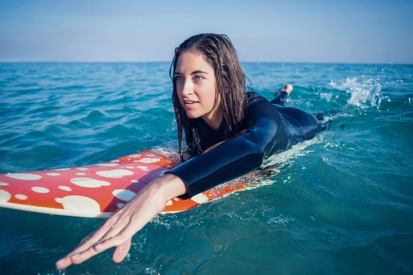Frau im Neoprenanzug mit Surfbrett am Strand — Stockfoto