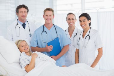 Team of doctor and patient looking at camera  clipart