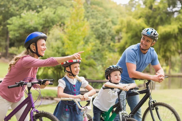 Família feliz em sua bicicleta no parque — Fotografia de Stock