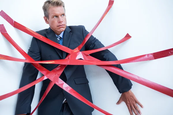 Businessman trapped by red tape — Stock Photo, Image