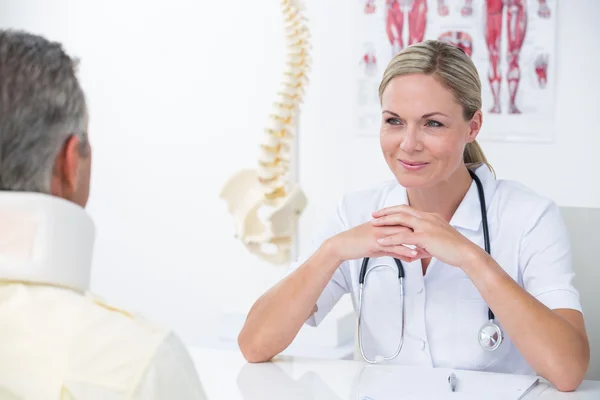 Medico guardando il paziente che indossa il collare — Foto Stock