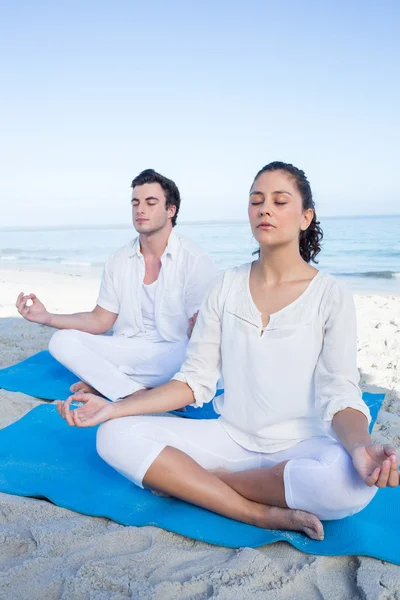 Happy couple doing yoga beside the water — Stock Photo, Image