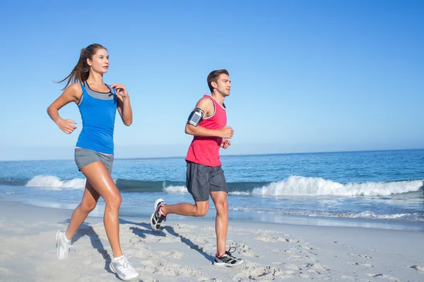 Coppia felice che corre insieme accanto all'acqua — Foto Stock