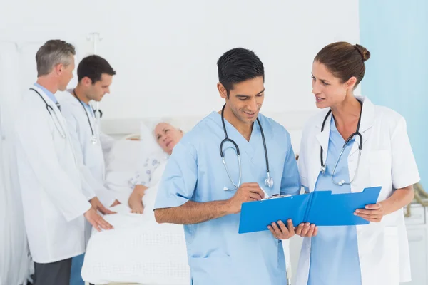 Report reading with patient behind — Stock Photo, Image