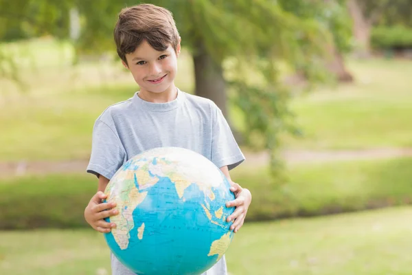 Lachende jongen houden een bol van de aarde in het park — Stockfoto