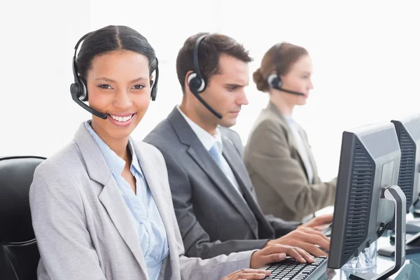 Mensen uit het bedrijfsleven met headsets met behulp van computers — Stockfoto