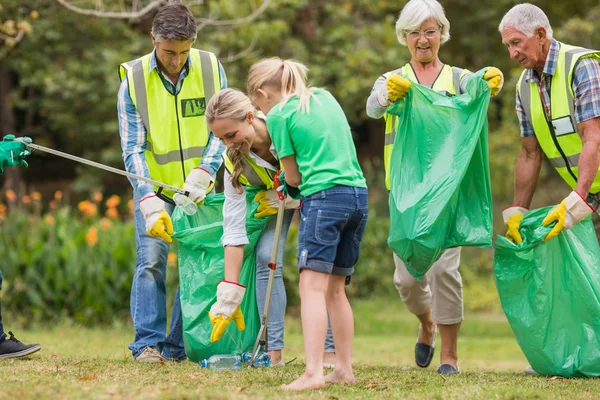 Happy family collecting rubbish — Stock Photo, Image