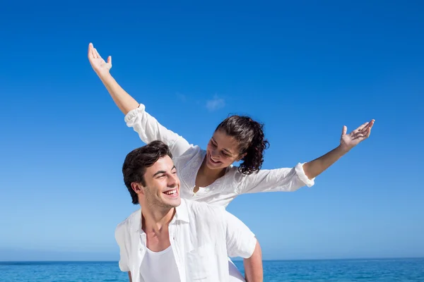 Schöner Mann gibt seiner Freundin Huckepack zurück — Stockfoto