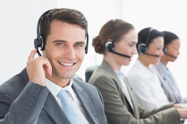 Mensen uit het bedrijfsleven met headsets met behulp van computers — Stockfoto