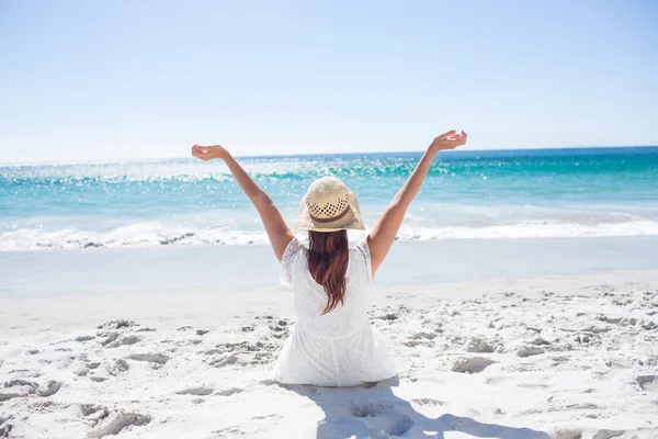 Brunette sitting in the sand and enjoying the air — Stock Photo, Image