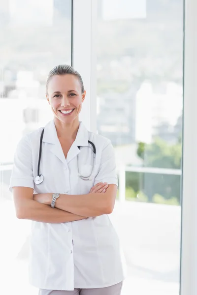 Médico sonriendo con los brazos cruzados — Foto de Stock