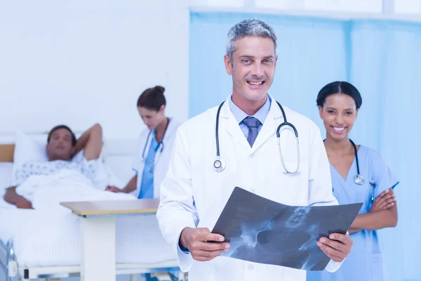 Doctor with colleague and patient behind — Stock Photo, Image