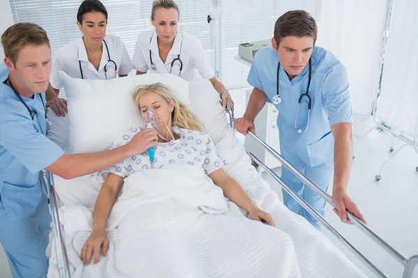 Equipe de médicos carregando paciente na maca — Fotografia de Stock