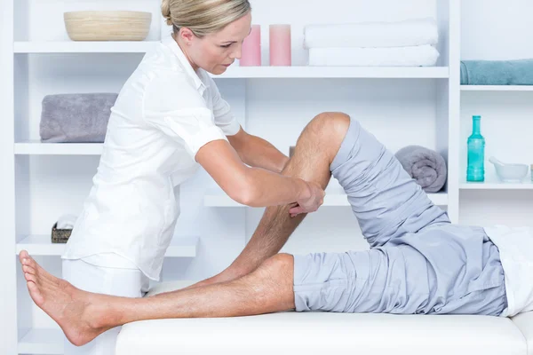 Фізіотерапевт робить масаж теляти своїй пацієнтці — стокове фото