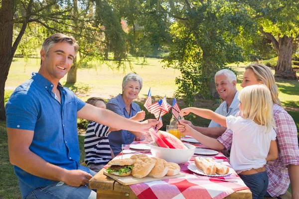 家族のピクニックを持つとアメリカの国旗を保持しています。 — ストック写真
