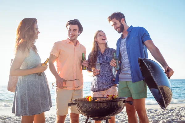 Happy friends doing barbecue and drinking beer — Stock Photo, Image