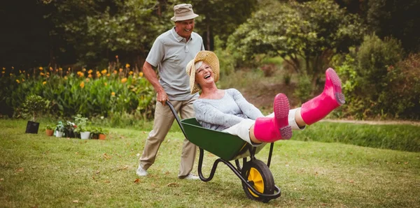 Feliz pareja de ancianos jugando con una carretilla — Foto de Stock