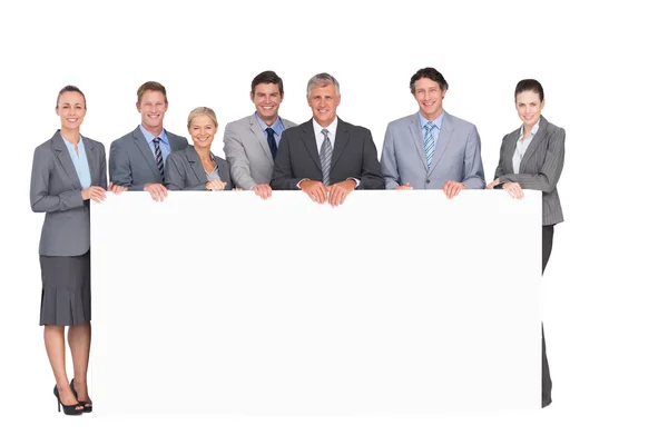 Smiling business team holding poster — Stock Photo, Image