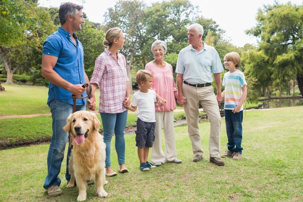 Lyckliga familjen i parken med sin hund — Stockfoto