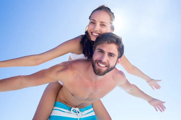 Bonito homem dando porquinho de volta para sua namorada — Fotografia de Stock