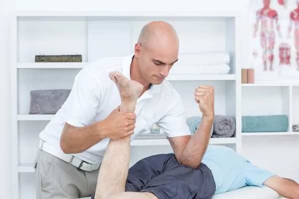 Physiothérapeute faisant massage des jambes à son patient — Photo