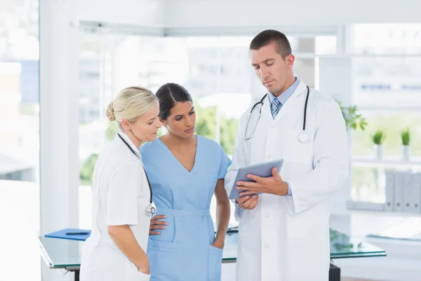 Médicos olhando juntos para tablet — Fotografia de Stock