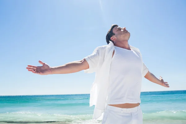 Mann streckt die Arme vor dem Meer aus — Stockfoto