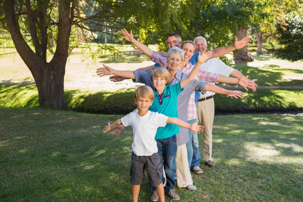 Gelukkige familie met armen gestrekt in het park — Stockfoto