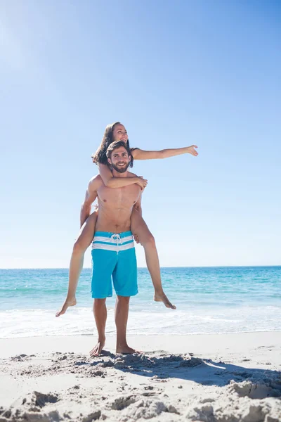 Bonito homem dando porquinho de volta para sua namorada — Fotografia de Stock