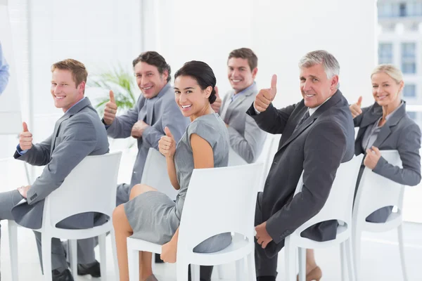 Lächelndes Geschäftsteam blickt während der Konferenz in die Kamera — Stockfoto