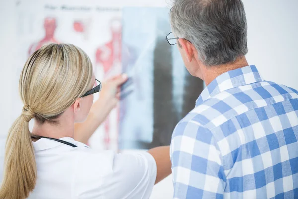 Doctor showing X rays to her patient — Stock Photo, Image